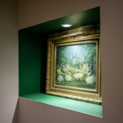 Un tableau encadré éclaire sur un mur vert